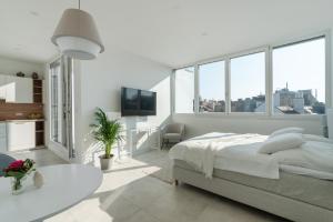 a white bedroom with a bed and a large window at Sophienne Apartments in Vienna
