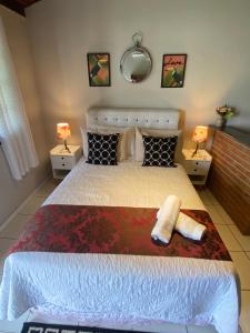 a bedroom with a bed with two towels on it at Vila Noel Centro in Penedo +22 photos