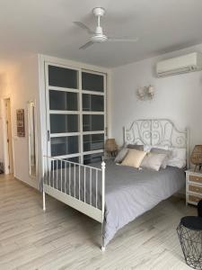 a bedroom with a white bed and a large window at Benal Beach Apartments in Benalmádena