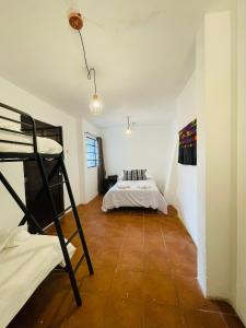 a room with a bunk bed and a bedroom with a ladder at Casa ELA in Antigua Guatemala
