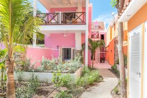 a pink and orange building with a walkway at Scuba Lodge & Suites in Willemstad