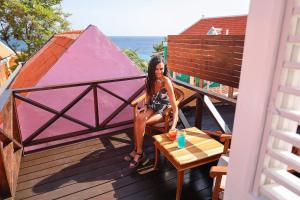 a woman sitting on a deck with a tent at Scuba Lodge & Suites in Willemstad