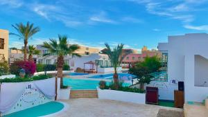 シャルム・エル・シェイクにあるBadawia Sharm Resortのプールとヤシの木があるリゾートの景色を望めます。