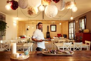 Um homem numa sala com uma mesa com comida. em Agriturismo Deviscio em Lecco