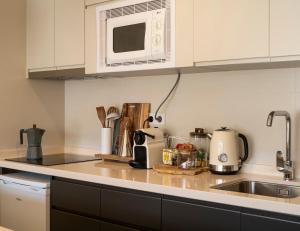 encimera de cocina con microondas y fregadero en Snow Home Apartment en Sierra Nevada