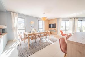 a dining room and living room with a table and chairs at Le Majestic Résidence LE MIND Vue Mer Exceptionnelle Grande Terrasse Privée Piscine Partagée sur le toit Hyper centre in La Grande-Motte