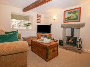 - un salon avec une cheminée et un canapé dans l'établissement Hope Cottage, à Castleton