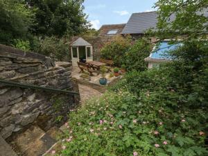 a garden with a bench and some pink flowers at Hope Cottage in Castleton