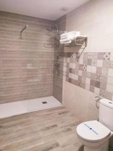 een badkamer met een toilet en een glazen douche bij Posada de la plata in Valdesalor