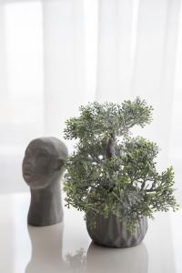 a plant in a vase next to a statue at RentWill apartments Valley of Roses in Sectorul Botanica