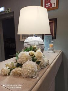 a table with a lamp and a bouquet of white flowers at Bellavista Avenida By BeGuest in Albufeira