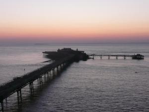 a pier stretches out into the ocean at sunset at The Kyrenia in Weston-super-Mare