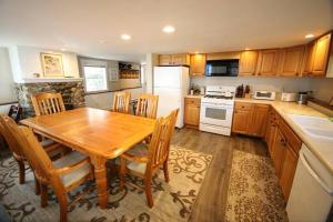 a kitchen with a wooden table and wooden chairs at Ski by day...Stargaze at the lake by night in Sunapee