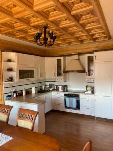 kuchnia z białymi szafkami i drewnianym sufitem w obiekcie Szaflary Dom w Szaflarach