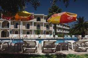 a hotel with chairs and umbrellas next to a swimming pool at Prokopis Studios in Laganas