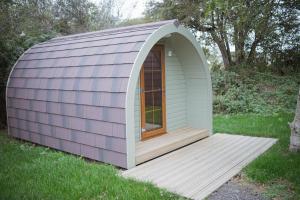 einem lila und weißen Schuppen mit einer Holzterrasse in der Unterkunft Chestnut Meadow Country Park in Sidley