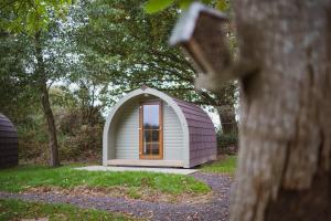 a small white shed with a window in the grass at Chestnut Meadow Country Park in Sidley