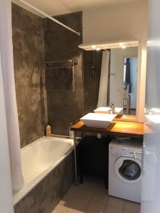 bagno con vasca, lavandino e lavatrice di T3 Raph & Gab's 3 Etoiles Jardins de Ramel WIFI Lave Linge a Luchon