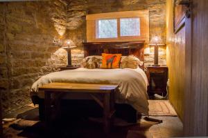 a bedroom with a bed in a stone wall at Suites in Private Game Reserve close to Aliwal North in Gladdegrond +52 photos