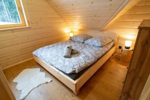 a bedroom with a bed in a wooden cabin at Świerkowe Chatki w Koniakowie in Koniaków