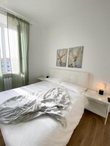 1 cama blanca en un dormitorio con ventana en B&B La Locanda Chic, en Grosseto