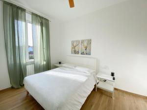 a white bedroom with a bed and a window at B&B La Locanda Chic in Grosseto