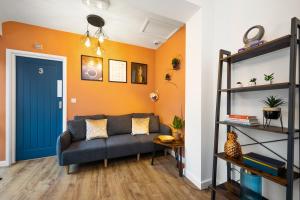 a living room with a couch and a blue door at 7 bedroom house ENSUITE Rooms, fully equipped kitchen, free WIFI, TVs in all rooms CITY CENTRE CLOSE TO A46 Inspire Homes in Coventry