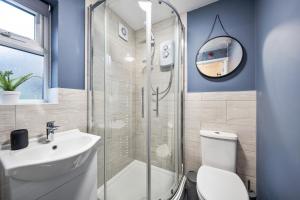 a bathroom with a shower and a toilet and a sink at 7 bedroom house ENSUITE Rooms, fully equipped kitchen, free WIFI, TVs in all rooms CITY CENTRE CLOSE TO A46 Inspire Homes in Coventry