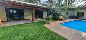 a house with a swimming pool in the yard at Honeybird self catering Accommodation in Hluhluwe