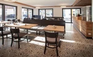 a restaurant with wooden tables and chairs and windows at Rose Bistro & Gästezimmer in Altensteig
