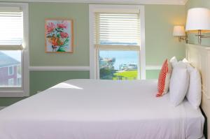 a white bed in a room with a window at Island House Hotel in Mackinac Island