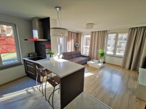 a kitchen and living room with a table and a couch at Sweet Lime Apartments Kaszubska 57m2 in Wrocław