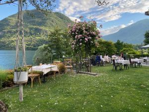 a garden with tables and chairs and a lake at Casa della Capra in Mergozzo