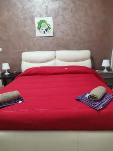 a bed with a red blanket on top of it at BED&FLY NEAR AIRPORT CATANIA FONTANAROSSA BAGNO PRIVATO In CAMERA in Catania