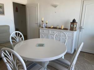 uma mesa branca e cadeiras numa sala de estar em Marina em Le Touquet-Paris-Plage