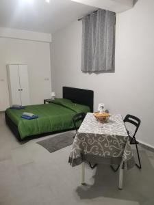 a room with a table and a bed and a table and chair at BED&FLY NEAR AIRPORT FONTANAROSSA reception h24 in Catania