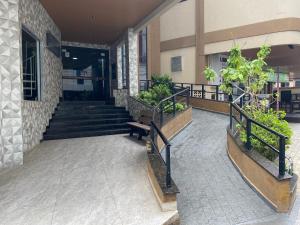 Un vestíbulo de un edificio con escaleras y un banco. en LINDO APARTAMENTO EM MEIA PRAIA-1 quadra do mar! Melhor localização!, en Itapema