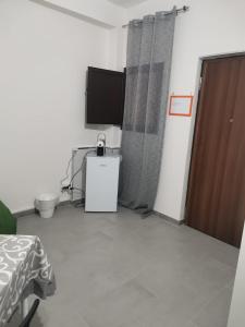 a room with a television and a door with a table at BED&FLY NEAR AIRPORT FONTANAROSSA reception h24 in Catania