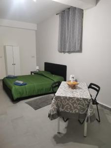 a bedroom with a bed, table, chair, and table cloth at BED AND FLY near airport fontanarossa catania gratis navetta aeroportuale in Catania