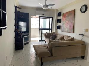 sala de estar con sofá y TV en LINDO APARTAMENTO EM MEIA PRAIA-1 quadra do mar! Melhor localização!, en Itapema