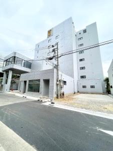 un edificio blanco al lado de una calle en Hotel Ritz Koshien en Nishinomiya