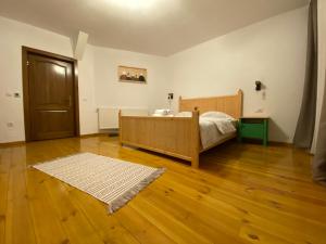 a bedroom with a bed and a wooden floor at Floare de Colț-Bran in Bran