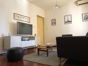 sala de estar con TV, sofá y mesa en Departamento en Ciudad de Mendoza en Mendoza
