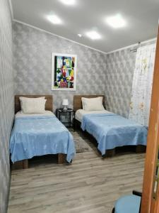 2 Betten in einem Zimmer mit blauer Bettwäsche in der Unterkunft Yellowunlimited Hotel in Kharkov