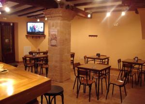 a restaurant with tables and chairs and a flat screen tv at Hostal La Cerollera in Cerollera