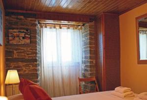 1 dormitorio con 1 cama y una ventana con cortinas en Aqua Rooms Sarria, en Sarria