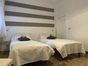two beds sitting next to each other in a room at Ca Marga Cannaregio - Central Venetian Style 2 bedroom apartment in Venice