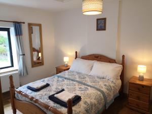 a bedroom with a bed with two towels on it at Bowkett Cottage in Cinderford