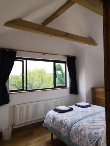 a bedroom with a bed and a large window at Bowkett Cottage in Cinderford