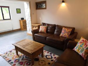 un soggiorno con divano e tavolino da caffè di Bowkett Cottage a Cinderford